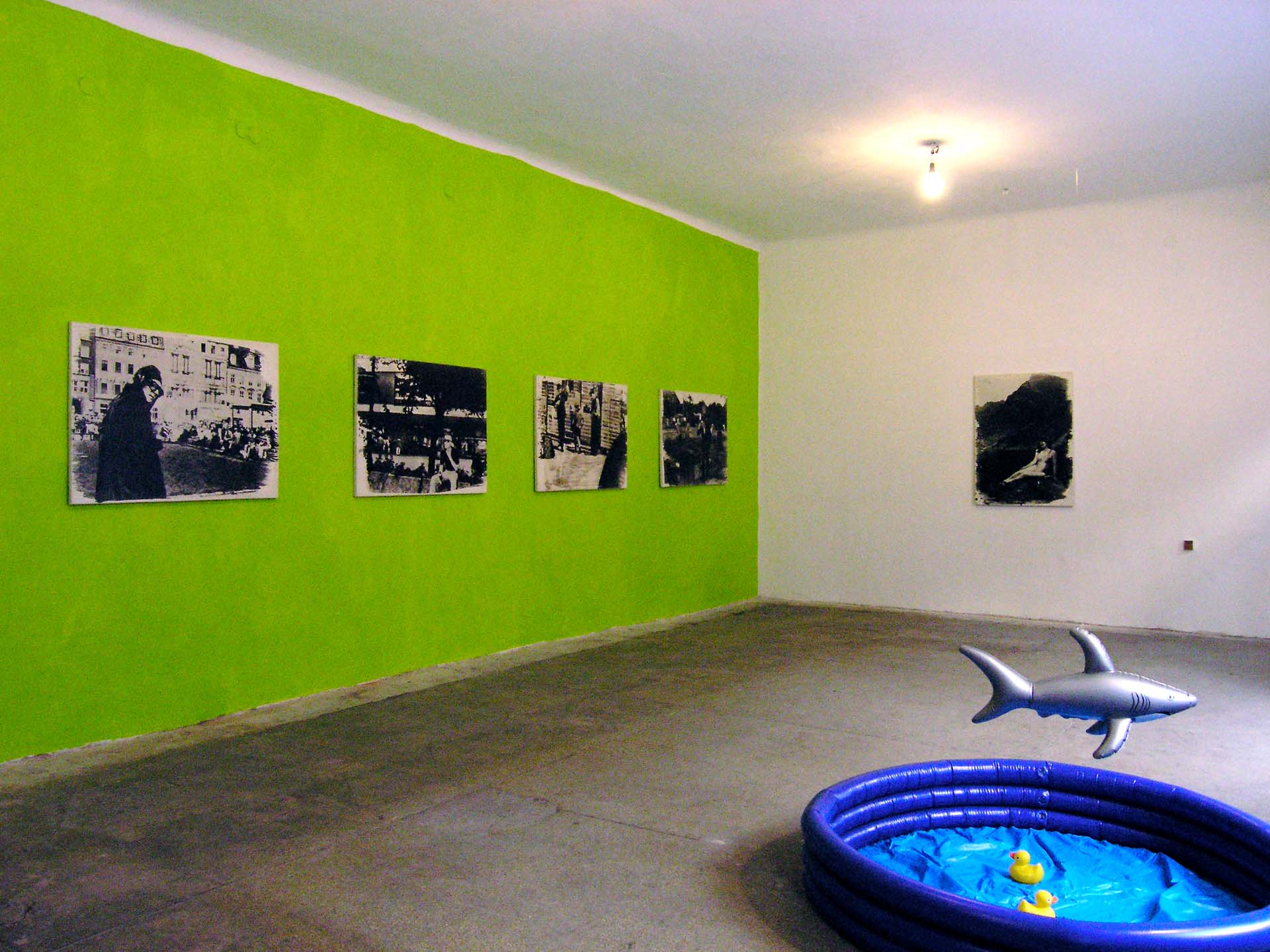 Joachim Seinfeld: view into the exhibition Podròz do Polski_ Beisl-Balagan at fabs, Warsaw-Praha, 2006Front right the paddling pool with two rubber ducks and an inflatable shark hovering over them.