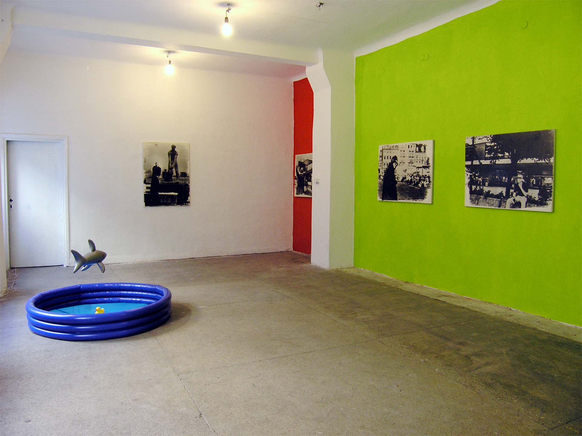 Joachim Seinfeld: view into the exhibition Podròz do Polski_ Beisl-Balagan at fabs, Warsaw-Praha, 2006On the left the paddling pool with two rubber ducks and an inflatable shark hovering over them.